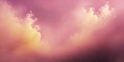 The primary subject of the image is a cloudy sky with a pinkish hue. The setting is a cloudy sky, and the visual style is a photo. The colors and mood of the image are predominantly pink, creating a warm and serene atmosphere.