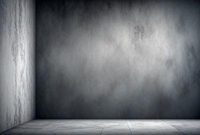 The primary subject of the image is a large, empty room with a white wall. The setting is a plain, white room with no furniture or decorations. The visual style is a black and white photo, which gives the image a classic and timeless appearance. The colors and mood of the image are predominantly neutral, with a sense of emptiness and simplicity.
