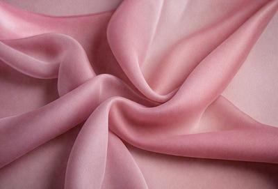 The primary subject of the image is a piece of pink fabric. The setting is a close-up of the fabric, showcasing its texture and color. The visual style is a realistic representation of the fabric, with no indication of digital art or illustration. The colors and mood of the image are predominantly pink, creating a soft and feminine atmosphere.