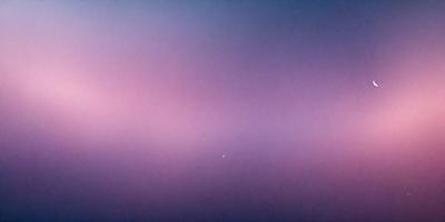 The primary subject of the image is a purple sky with clouds. The setting is a cloudy sky, and the visual style is a photo. The colors and mood of the image are predominantly purple, creating a serene and calming atmosphere.