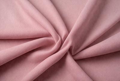 The primary subject of the image is a pink fabric, which is the main object, scene, or focus of the image. The setting is a pink background, and the visual style is a photo. The colors and mood of the image are predominantly pink, creating a warm and inviting atmosphere.
