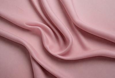 The primary subject of the image is a piece of pink fabric. The setting is a close-up view of the fabric, showcasing its texture and color. The visual style is a realistic representation of the fabric, with no indication of digital art or illustration. The colors and mood of the image are predominantly pink, creating a soft and feminine atmosphere.