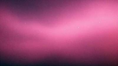 The primary subject of the image is a pink sky, which creates a unique and visually striking scene. The setting is a cloudy sky, and the visual style appears to be a photo. The dominant colors in the image are pink, which gives the sky a warm and vibrant atmosphere.
