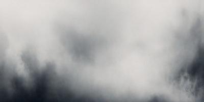 The primary subject of the image is a cloudy sky. The setting is a cloudy day with a dark, gloomy atmosphere. The visual style is a photo of the cloudy sky. The colors and mood are predominantly dark and moody, with the clouds being the main focus of the image.