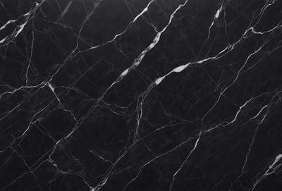 The primary subject of the image is a black marble countertop. The setting is a kitchen, with the countertop being the main focus of the scene. The visual style is a close-up of the marble countertop, showcasing its texture and pattern. The colors and mood of the image are predominantly dark, with the black marble providing a striking contrast against the darker background.