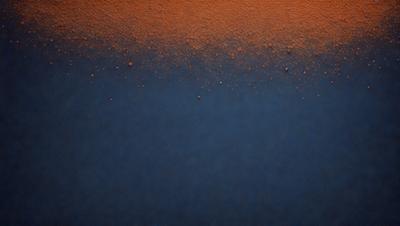 The primary subject of the image is a blue background with orange specks. The setting is a dark blue surface, and the visual style appears to be a digital art or illustration. The dominant colors are blue and orange, creating a contrasting and visually striking scene.