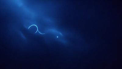The primary subject of the image is a blue sky with a few streaks of light. The setting is a cloudy sky, and the visual style appears to be a photo. The colors in the image are predominantly blue, creating a calm and serene atmosphere.