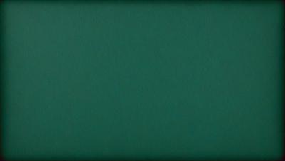 The primary subject of the image is a large, dark green surface. The setting is a room with a green wall, and the visual style is a close-up of the green wall. The colors and mood of the image are predominantly dark and moody, with the green wall being the main focus.