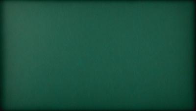 The primary subject of the image is a green background. The setting is a dark room, and the visual style is a close-up of the green background. The colors and mood of the image are predominantly green, creating a calm and serene atmosphere.