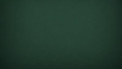 The primary subject of the image is a green background. The setting is a dark room, and the visual style is a photo. The colors and mood of the image are predominantly dark and moody, with the green background being the main focus.
