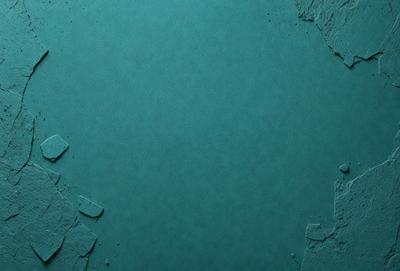 The primary subject of the image is a blue surface, which appears to be a piece of paper or a wall. The setting is a room with a blue background, and the visual style is a close-up of the blue surface. The colors and mood of the image are predominantly blue, creating a calm and serene atmosphere.