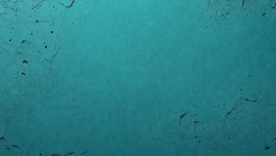 The primary subject of the image is a blue surface, which appears to be a piece of paper or a wall. The setting is indoors, and the visual style is a close-up of the blue surface. The colors and mood of the image are predominantly blue, creating a calm and serene atmosphere.