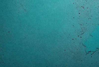 The primary subject of the image is a blue surface, which appears to be a wall or a piece of fabric. The setting is a room with a blue background, and the visual style is a close-up of the blue surface. The colors and mood of the image are predominantly blue, creating a calm and serene atmosphere.