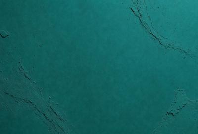 The primary subject of the image is a large, blue, textured surface. The setting is a dark, blue background, which creates a moody atmosphere. The visual style is a close-up of the blue surface, showcasing its texture and depth. The colors and mood of the image are predominantly dark and blue, giving it a mysterious and intriguing appearance.