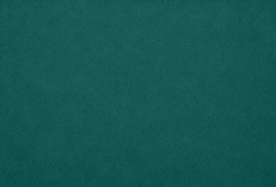 The primary subject of the image is a green cloth, which is the main object, scene, or focus of the image. The setting or background is a dark green surface, which is visible. The visual style of the image is a photo, as it is a real-life photograph. The dominant colors in the image are green, which creates a calm and soothing atmosphere.