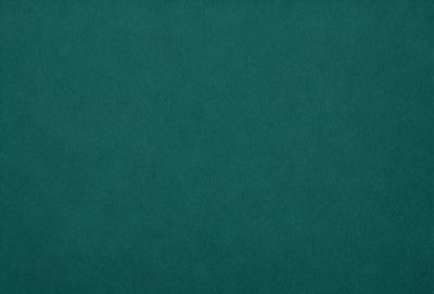 The primary subject of the image is a large, dark green cloth. The setting is a dark room, and the visual style is a close-up of the cloth. The colors and mood of the image are predominantly dark and moody, with the green cloth being the main focus.