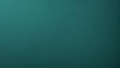 The primary subject of the image is a large, dark blue wall. The setting is a room with a green background, which creates a contrasting effect. The visual style is a close-up of the wall, showcasing its color and texture. The dominant colors are blue and green, giving the image a calm and serene atmosphere.