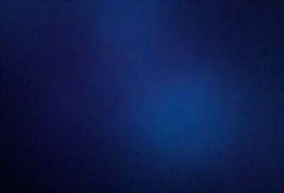 The primary subject of the image is a blue sky with a few clouds. The setting is a dark blue background, which creates a contrasting effect with the sky. The visual style is a photo, capturing the natural beauty of the sky. The colors and mood of the image are predominantly dark and moody, with the blue sky and clouds providing a sense of depth and tranquility.