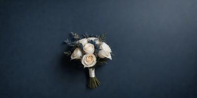 The primary subject of the image is a bouquet of white flowers, which are arranged in a vase. The setting is a dark blue wall, which serves as the backdrop for the bouquet. The visual style of the image is a close-up of the flowers, showcasing their details and beauty. The colors and mood of the image are predominantly dark and moody, with the blue wall and the white flowers creating a sense of elegance and sophistication.