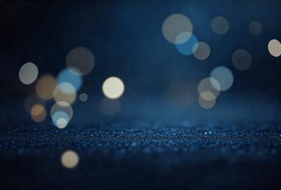 The primary subject of the image is a blue background with a pattern of bright lights, creating a visually striking and captivating scene. The setting appears to be a dark room, with the lights creating a contrast against the darkness. The visual style of the image is a combination of photo and digital art, as it captures the essence of a nighttime cityscape with a modern twist. The colors and mood of the image are predominantly blue, creating a sense of calmness and tranquility.