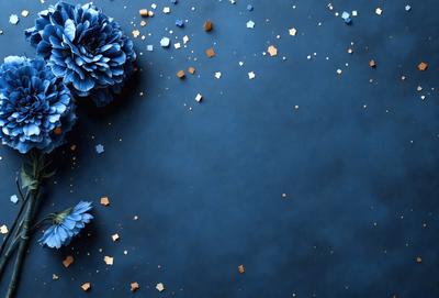 The primary subject of the image is a blue background with a few blue flowers scattered across it. The setting appears to be a dark blue surface, possibly a table or a wall. The visual style of the image is a photo, capturing the beauty of the blue flowers against the dark blue background. The colors and mood of the image are predominantly blue, creating a calm and serene atmosphere.
