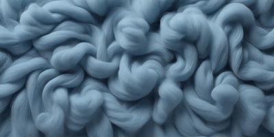 The primary subject of the image is a close-up of a blue, woolly fabric. The setting is a blue background, which creates a striking contrast with the fabric. The visual style is a combination of a photo and a digital art, as the fabric appears to be a blend of both. The colors and mood of the image are predominantly blue, creating a calm and serene atmosphere.