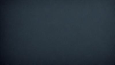 The primary subject of the image is a dark blue background. The setting is a black background, which creates a dramatic and moody atmosphere. The visual style is a simple, monochromatic design. The colors and mood are predominantly dark and mysterious.