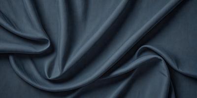 The primary subject of the image is a blue fabric, which is the main object, scene, or focus of the image. The setting or background is a dark blue cloth, and the visual style is a close-up of the fabric. The colors and mood of the image are predominantly dark blue, creating a calm and serene atmosphere.