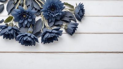 The primary subject of the image is a bouquet of blue flowers. The flowers are arranged in a vase, and they are placed on a white surface, which could be a table or a counter. The setting appears to be indoors, and the visual style is a close-up of the flowers, showcasing their beauty and details. The dominant colors in the image are blue and white, creating a calm and serene atmosphere.