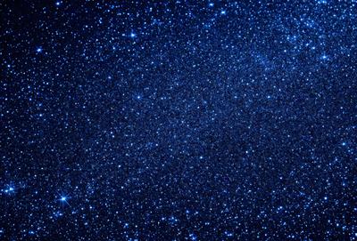 The primary subject of the image is the night sky filled with stars. The setting is a dark, star-filled sky, and the visual style is a photo of the night sky. The colors and mood of the image are predominantly dark and serene, with the stars providing a sense of wonder and tranquility.