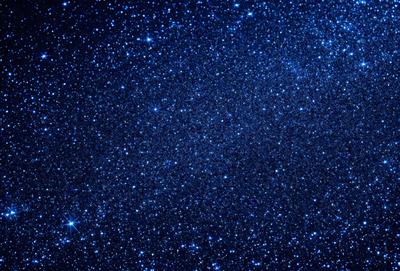 The primary subject of the image is the night sky filled with stars. The setting is a dark, star-filled sky, and the visual style is a photo of the night sky. The colors and mood of the image are predominantly dark and serene, with the stars providing a sense of wonder and tranquility.