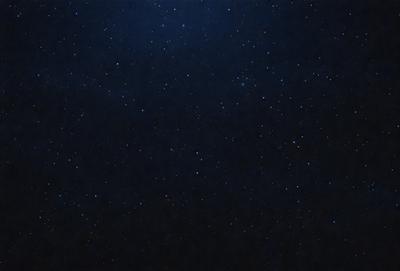 The primary subject of the image is the night sky, which is filled with stars. The setting is a dark, star-filled sky, and the visual style is a photo. The colors and mood of the image are predominantly dark and serene, with the stars providing a sense of depth and beauty.