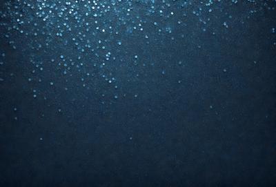 The primary subject of the image is a blue background with a pattern of white dots. The setting appears to be a dark room, and the visual style is a close-up of the blue background with the white dots. The colors and mood of the image are predominantly dark and moody, with the blue background and white dots creating a visually striking contrast.