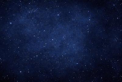 The primary subject of the image is the night sky, which is filled with stars. The setting is a dark, star-filled sky, and the visual style is a photo. The colors and mood of the image are predominantly dark and serene, with the stars providing a sense of depth and beauty.