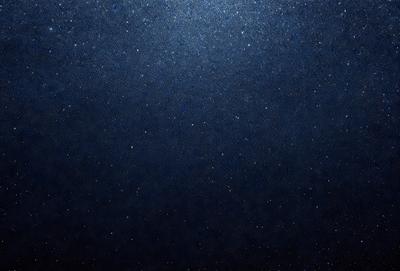 The primary subject of the image is the night sky, which is filled with stars. The setting is a dark, star-filled sky, and the visual style is a photo. The colors and mood of the image are predominantly dark and serene, with the stars providing a sense of depth and beauty.