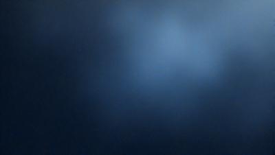The primary subject of the image is a blue sky with a few clouds. The setting is a dark blue background, which contrasts with the lighter blue of the sky. The visual style is a photo, capturing the beauty of the sky. The colors and mood of the image are serene and peaceful, with the blue hues creating a calming atmosphere.