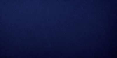 The primary subject of the image is a large, dark blue surface. The setting is a vast, open space with no visible objects or people. The visual style is a simple, monochromatic image with no additional elements or textures. The colors and mood of the image are predominantly dark and moody, with the blue surface creating a sense of depth and vastness.