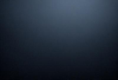 The primary subject of the image is a dark blue sky. The setting is a vast, open space with no visible landmarks or objects. The visual style is a black and white photo, which adds a sense of depth and contrast to the scene. The colors and mood of the image are predominantly dark and moody, with the blue sky serving as the main focal point.