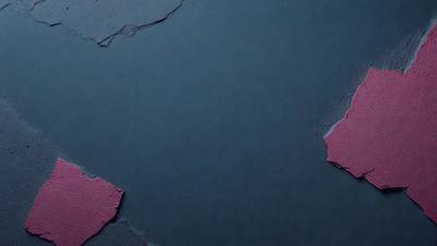The primary subject of the image is a piece of red fabric, which is placed on a grey background. The visual style of the image is a photo, and the colors and mood convey a sense of contrast and vibrancy.