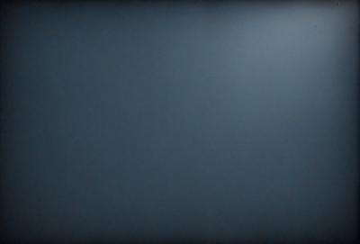 The primary subject of the image is a blue wall. The setting is a dark room, and the visual style is a photo. The dominant colors are blue and black, creating a calm and serene atmosphere.