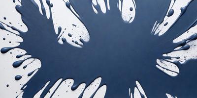 The primary subject of the image is a blue background with a splash of paint on it. The setting appears to be a white wall, and the visual style is a combination of a photo and digital art. The dominant colors are blue and white, creating a calm and serene atmosphere.