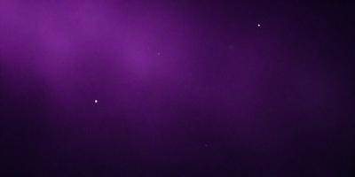 The image is a purple background with a few stars scattered throughout the scene. The primary subject is the purple background, which creates a unique and visually striking atmosphere. The setting is a night sky, and the visual style is a combination of a photo and digital art. The colors and mood are predominantly purple, creating a sense of calmness and tranquility.