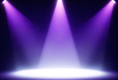 The primary subject of the image is a purple light shining on a white stage. The setting is a dark room with a purple light illuminating the stage. The visual style is a digital art or illustration, creating a dramatic and artistic atmosphere. The colors and mood are dominated by purple and white, giving the image a sense of drama and intensity.