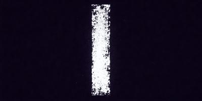 The primary subject of the image is a white and black striped object, which appears to be a white line on a black background. The setting is a dark room, and the visual style is a black and white photo. The colors and mood of the image are predominantly dark and moody, with the white line standing out against the black background.