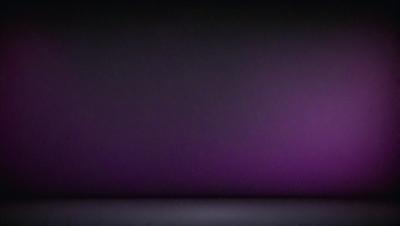 The primary subject of the image is a purple wall. The setting is a dark room with a purple hue. The visual style is a photo, and the colors and mood convey a sense of mystery and intrigue.