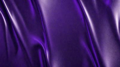 The primary subject of the image is a close-up of a purple fabric, which appears to be a piece of leather. The setting is a dark background, which contrasts with the purple fabric. The visual style is a close-up, focusing on the details of the purple fabric. The colors and mood of the image are predominantly purple, creating a sense of luxury and sophistication.