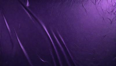 The primary subject of the image is a purple fabric, which appears to be a piece of leather. The setting is a close-up view of the fabric, showcasing its texture and color. The visual style is a realistic representation of the fabric, with no indication of it being a photo, digital art, illustration, drawing, pattern, texture, or clipart. The colors and mood of the image are predominantly purple, giving it a rich and luxurious appearance.