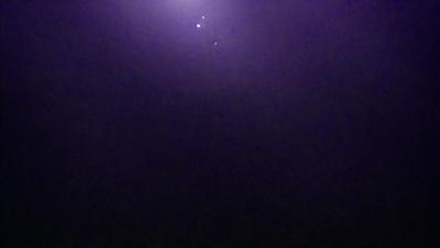 The image is a purple and black night sky with a few stars visible. The primary subject is the night sky, and the setting is a dark, star-filled background. The visual style is a nighttime scene, and the colors and mood are dark and mysterious.