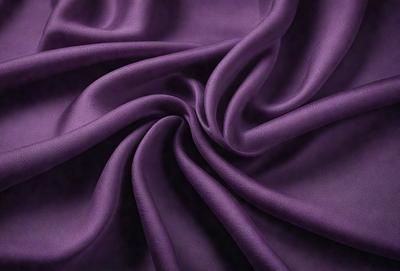 Purple fabric with a pattern of swirls and curls.