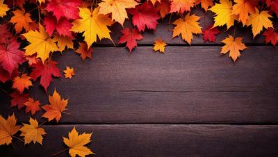 The primary subject of the image is a wooden surface with a few leaves scattered on it. The setting is a wooden table, and the visual style is a photo. The colors and mood of the image are predominantly brown and orange, giving it a warm and natural atmosphere.